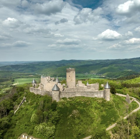 Ansicht der Burgruine Nürburg umgeben von der Landschaft im Hintergrund die Eifelhöhen. 