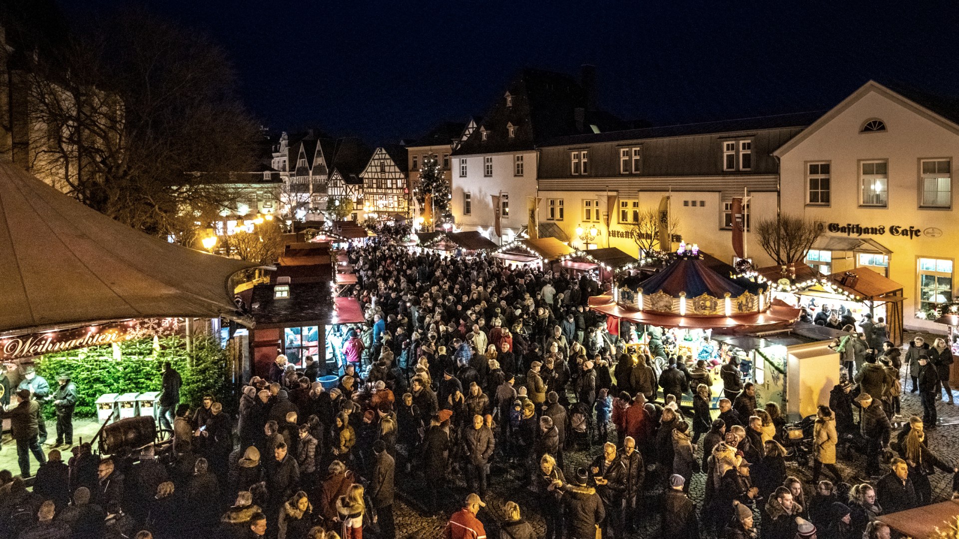 Blick auf den Weihnachtsmarkt in Ahrweiler mit Buden und Menschen 